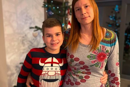Sheila und Sohn vor dem weihnachtlich geschmückten Baum