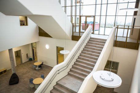 Die große Treppe und Fensterwand dominieren den Eingangsbereich