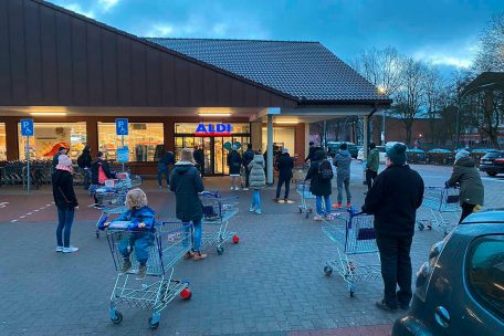 Zahlreiche Kunden warten am Samstag auf die Öffnung einer Filiale von Aldi im Hamburger Stadtteil Eimsbüttel