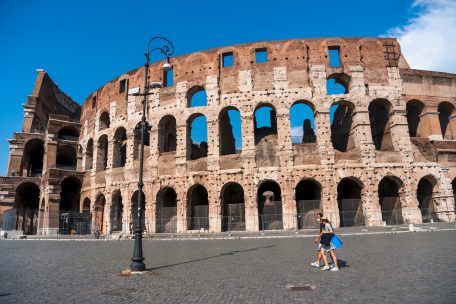 Menschen spazieren vor dem Kolosseum in der italienischen Hauptstadt Rom
