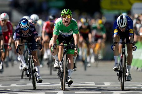 Mark Cavendish (M) aus Großbritannien vom Team Deceuninck-Quick-Step im Grünen Trikot des Sprintbesten jubelt, als er die Ziellinie überquert 