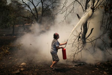 Türkei, Cokertme: Eine Frau benutzt einen Feuerlöscher während eines Waldbrandes im Dorf Cokertme in der Region Mugla. Die heftigen Waldbrände in Teilen Südeuropas und der Türkei lassen weiterhin kaum nach.