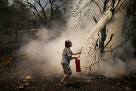 Türkei, Cokertme: Eine Frau benutzt einen Feuerlöscher während eines Waldbrandes im Dorf Cokertme in der Region Mugla. Die heftigen Waldbrände in Teilen Südeuropas und der Türkei lassen weiterhin kaum nach. 