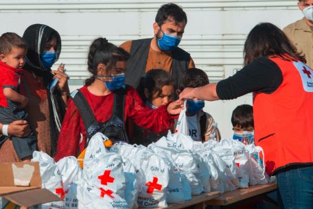 Helfer des Roten Kreuzes verteilen Hilfsgüter an ankommende Flüchtlinge auf dem US-Stützpunkt im deutschen Ramstein