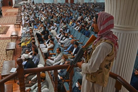 Nie ohne Waffe im Bild: Ein Taliban-Kämpfer bei einer Ansprache des Hochschulministers