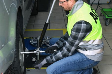 Alex Lanners vom ACL lockert die Schrauben mit dem Radkreuz, wenn das Auto noch gar nicht in der Luft ist – erst später werden die Schrauben ganz abgezogen