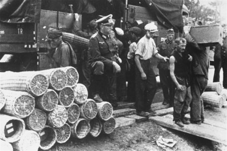 Wehrmacht-Angehörige überwachen jüdische Zwangsarbeiter beim Beladen eines LKW mit Munitionskisten, Izbica, Juli 1941. Fotograf unbekannt.