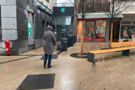 Die dunklen Linien auf dem Boden sollen Menschen wie Colette Schmitz den Weg zeigen. In diesem Fall würde die Frau mit Sehhandicap allerdings geradewegs gegen die unachtsam abgestellten Mülltonnen laufen.