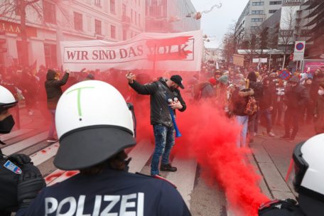 Demonstranten sind während eines Protests in Wien gegen die Corona-Maßnahmen in dem Land von der Polizei konfrontiert, während roter Rauch aufsteigt