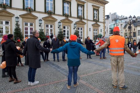 Auf dem Foto ist eine Menschenkette zu sehen, die im Zuge der „Orange Week“ gebildet wurde, um auf Gewalt gegen Mädchen und Frauen aufmerksam zu machen