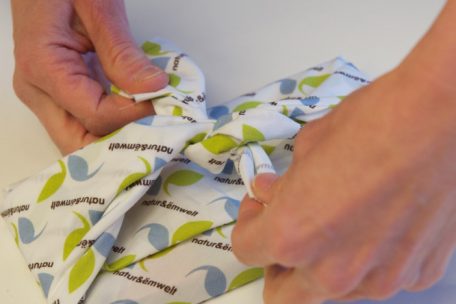 Mit der japanischen Falttechnik „Furoshiki“ können Geschenke in Stoff verpackt werden. Dabei werden die Stoffenden am Ende in einem schönen Knoten miteinander verschlungen.