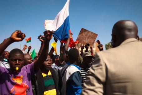 Des manifestants se rassemblent à Ouagadougou pour montrer leur soutien aux militaires tout en tenant une bannière anti-France et en agitant un drapeau russe, le 25 octobre 2022