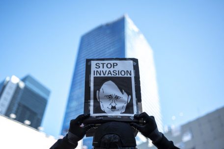 Ein Demonstrant hält ein Plakat, während sich Menschen im Tokioter Stadtteil Shibuya versammeln, um gegen den Einmarsch Russlands in die Ukraine zu protestieren