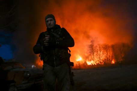 Ein ukrainischer Soldat vor einem in Flammen stehenden Warenhaus in Kiew