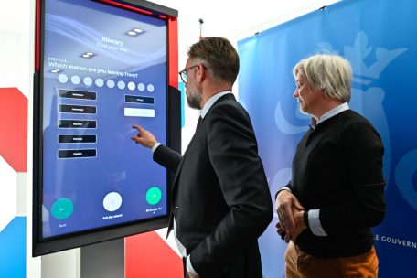 Wirtschaftsminister Fayot testet ein kontaktloses Terminal. Olivier Raulot – CEO des Unternehmens iNUI – leitet ihn dabei an.