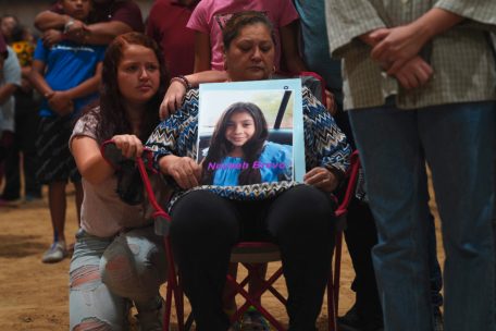 Eine Frau hält ein Foto von einem der getöteten Kinder vor sich