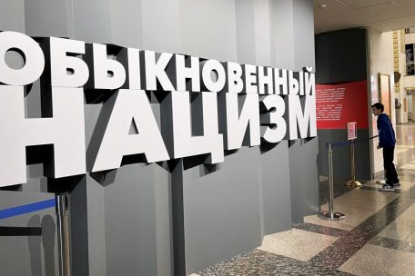 Ein Junge schaut verstohlen in den Ausstellungsraum. Er ist mit „Gewöhnlicher Nazismus“ überschrieben.