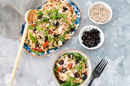 Der bunte griechische Salat mit getrockneten Tomaten, Feta, Oliven, Rucola und den Kritharakinudeln bringt Farbe in jedes BBQ-Buffet