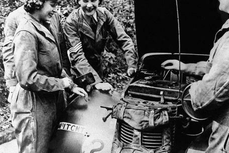 Die damalige Prinzessin Elizabeth (vorne links) lernt an einem Militärfahrzeug der Gruppe Austin 10 Light Utility die Fahrzeugwartung