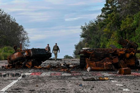 Reste von zerstörten gepanzerten Fahrzeugen säumen eine Straße in Balakliya