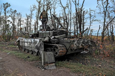 Nahe der Stadt Isjum steht ein ukrainischer Soldat auf einem zerstörten russischen Panzer
