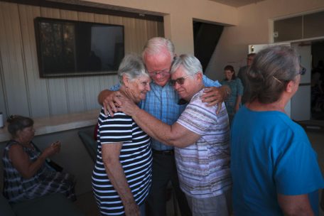 Pastor Bob Kasten umarmt Gemeindemitglieder nach dem Sonntagsgottesdienst vor der Southwest Baptist Church, die während des Hurrikans Ian am 2. Oktober 2022 in Fort Myers, Florida, beschädigt wurde