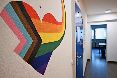 Gleich neben der Eingangstür ziert die Progressive-LGBTQIA+-Flagge die Wand. Der Regenbogen, der von der Herzform abgeht, braucht aber noch zwei Farben. 