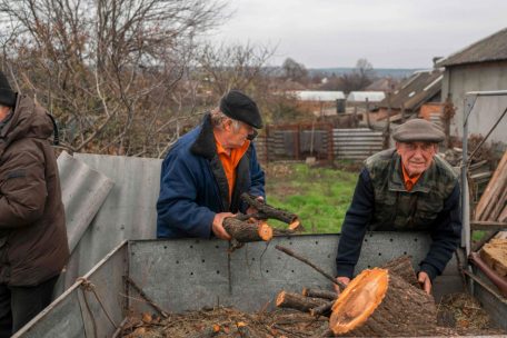 In Siversk, einer Stadt in der Ostukraine, die vor einigen Tagen von russischen Truppen angegriffen wurde, erhalten ukrainische Männer am 11. November 2022 Holz für den Winter
