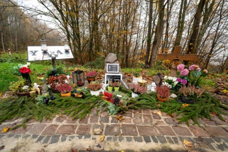 Ein Gedenkstein und Blumen sind in der Nähe des Tatorts an der K22 bei Kusel aufgestellt, wo Ende Januar 2022 zwei Polizisten im Dienst getötet wurden