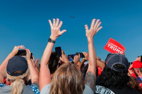 Die Hände zum Himmel: Anhänger des ehemaligen US-Präsidenten Donald Trump jubeln, als sein Flugzeug über die Wahlkampfkundgebung in Waco, Texas, fliegt