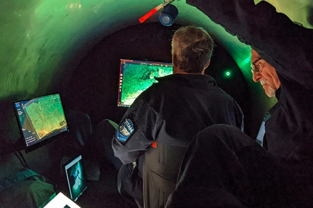 Dieses Foto zeigt Mitarbeiter bei der Arbeit im Inneren des Tauchboots „Titan“, mit dem die Wrackstelle der Titanic besucht wird. Einsatzkräfte haben am Dienstag, 20. Juni, möglicherweise ein Lebenszeichen der Insassen gehört. Suchteams hätten alle 30 Minuten eine Art von Klopfgeräuschen in der Region registriert, in dem das Tauchboot vermutet werde, hieß es in einem internen Memo der US-Regierung, aus dem Medien zitierten.