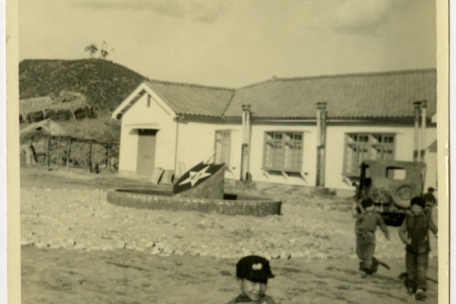 Ein Waisenkind steht vor einem Heim, das in Korea gebliebene US-Soldaten der „2nd Infantry Division“ bauen ließen (Courtesy of Tennessee State Library and Archives, David Franklin Brock (image has been altered from the original)