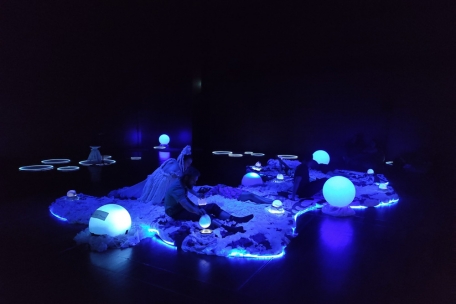 Ungewohnt unmetaphorisch: ein Klangteppich, auf dem die Zuschauer*innen liegen und Leuchtbälle betätigen können