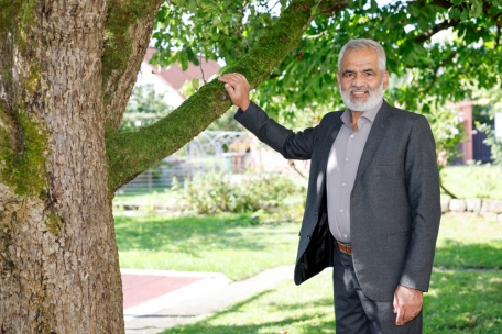 Mohammed Tarik aus Afghanistan steht im Garten seines Mietshauses. Als die Taliban vor zwei Jahren Kabul einnahmen, flohen Zehntausende aus Afghanistan – auch Tarik: Er lebt mit seiner Frau und zwei Töchtern in einem Dorf bei Bamberg (Bayern).