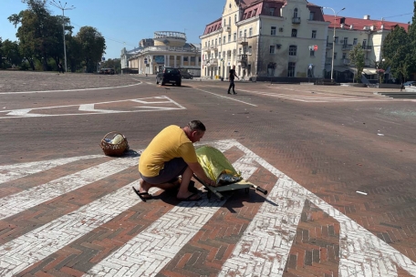 Auf diesem von der Nationalen Polizei der Ukraine via AP zur Verfügung gestellten Foto bedeckt ein Mann eine Leiche nach einem Angriff in der nordukrainischen Stadt Tschernihiw.