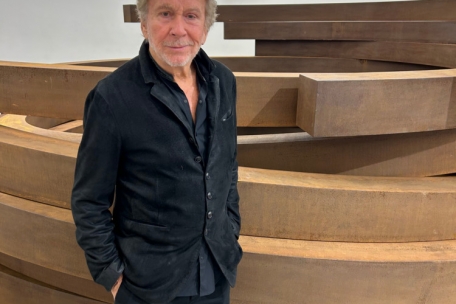 Bernar Venet posiert vor seiner Großskulptur, die er mit einer Performance verändert hat