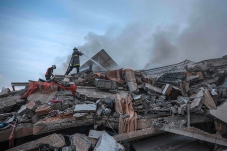 Palästinensische Feuerwehrleute löschen ein Feuer, das in einem durch israelische Luftangriffe zerstörten Wohnhaus in Gaza-Stadt wütete