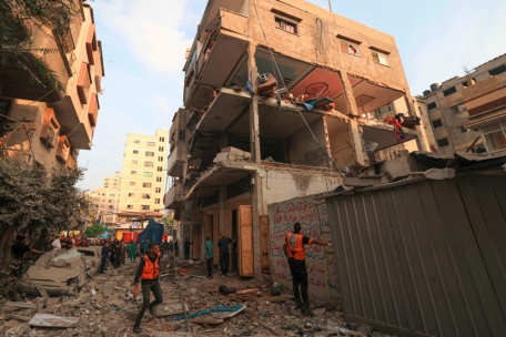 Rettungskräfte gehen nach israelischen Luftangriffen in Gaza-Stadt am frühen Sonntagmorgen eine mit Trümmern übersäte Straße entlang
