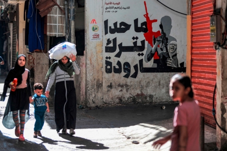 Menschen gehen am 7. November 2023 an einer Wandmalerei im Shatila-Lager für palästinensische Flüchtlinge in einem südlichen Vorort von Beirut vorbei