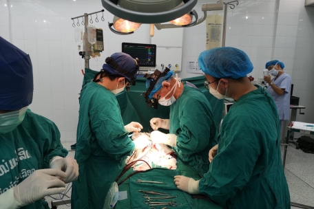 Ein Herzchirurg von ADS wird von laotischen Medizinern während einer Operation assistiert