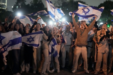 Eine Gruppe junger Israelis mit wehenden Fahnen bejubelt am 26.11. die Landung eines Hubschraubers mit ehemaligen Geiseln, die von der islamistischen Hamas aus dem Gazastreifen frei gelassen wurden.