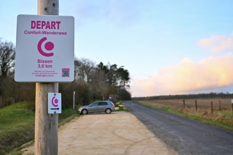 Der Komfort-Wanderweg in Bissen beginnt an einem Parkplatz, von dem aus man den Schildern mit rosafarbener Beschriftung folgt