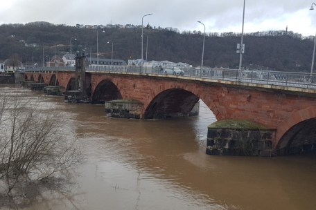 Langsam, aber unsicher: Auch die Mosel steigt – und lässt am Mittwochmittag in Trier die hohen Bögen der Römerbrücke scheinbar schrumpfen 