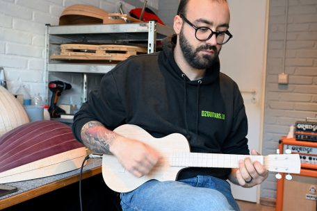 Der „luthier“ mit einer selbstgebauten elektrischen Ukulele