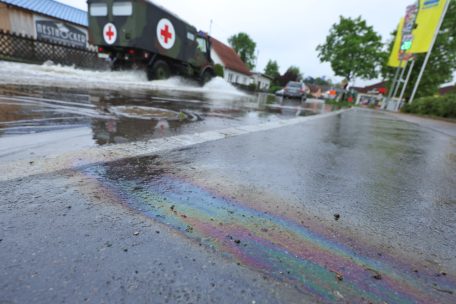 Bayern, Offingen: Eine mutmaßlich ölartige Flüssigkeit ist am Montag am Rande einer überfluteten Straße zu sehen. Hier war der Fluss Mindel über die Ufer getreten.