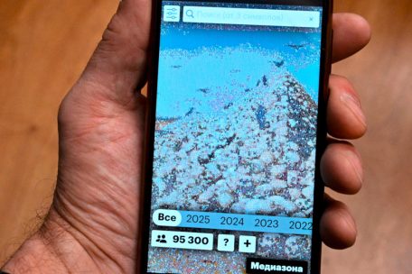 A smartphone screen shows a special website of Russian independent media outlet Mediazona dedicated to the Russian losses in its military campaign in Ukraine featuring an image of Russian artist Vasily Vereshchagin's painting "The Apotheosis of War" - depicting a huge pile of skulls, made of portraits of killed Russian soldiers, on February 25, 2025. (Photo by AFP)