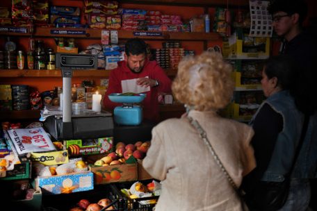 Betrieb eines Obstladens in Madrid während des Stromausfalls – mit Kerze und analoger Waage