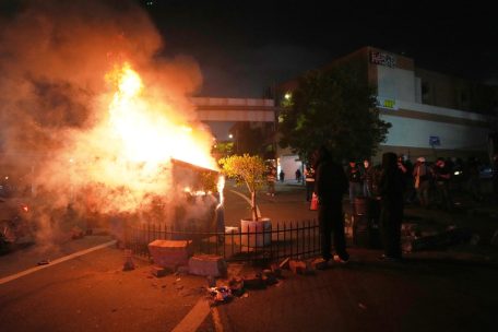 Demonstranten legen Feuer in einem Müllcontainer in der Nähe des Metropolitan Detention Center in der Innenstadt. Sie protestieren gegen Operationen der Bundeseinwanderungsbehörde, die Dutzende Menschen festgenommen hat.