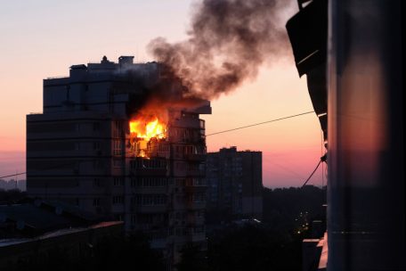 Der Morgen graut und ein mehrstöckiges Wohnhaus steht nach einem nächtlichen russischen Drohnenangriff in Flammen