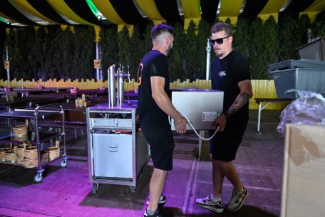 Stefan und Laurent tragen eine der Fritteusen in die Küche